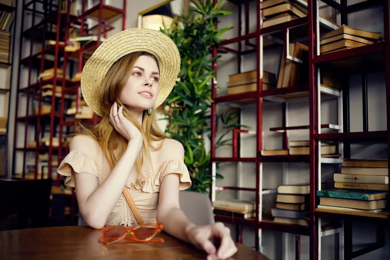Красивая женщина с книгой в руках в кафе