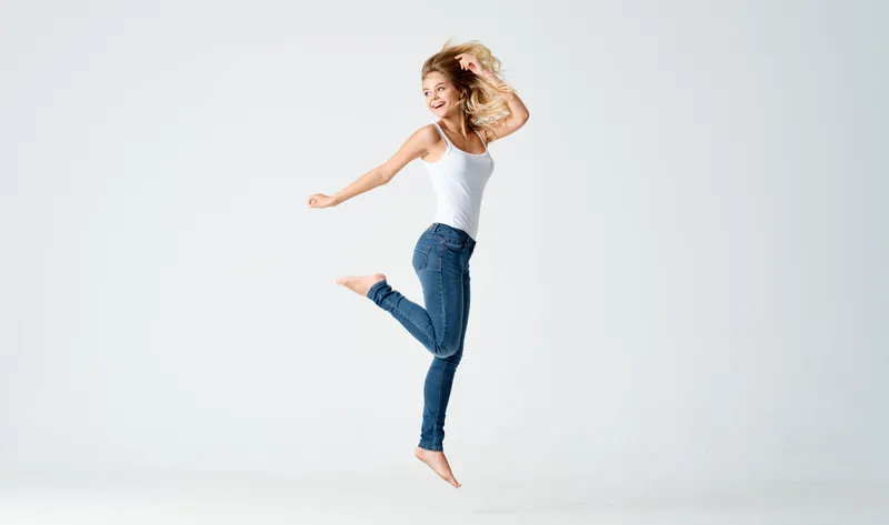 Женщина выполняет прыжковое движение во время спортивной тренировки