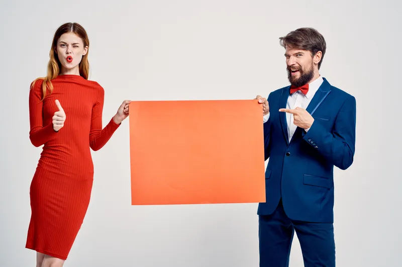 Мужчина и женщина на рекламном постере с красным маком, посвящённом скидкам