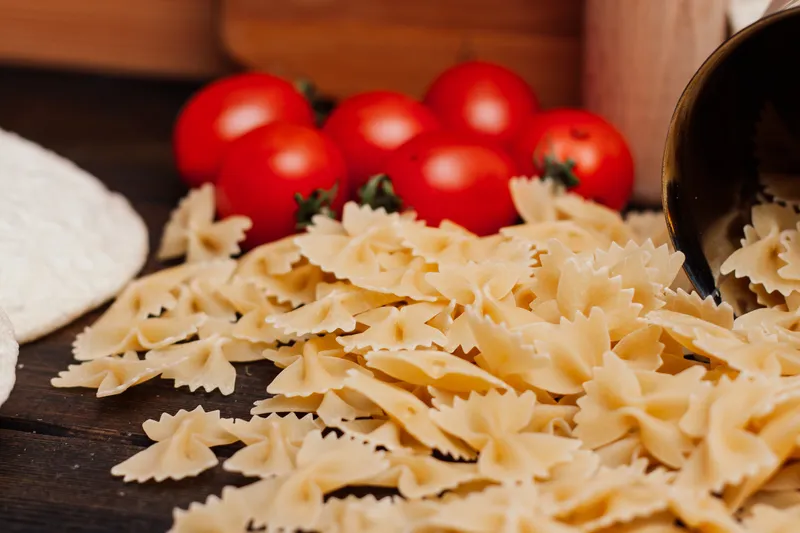 Приготовление итальянской кухни: на кухонном столе лежит мука и другие продукты