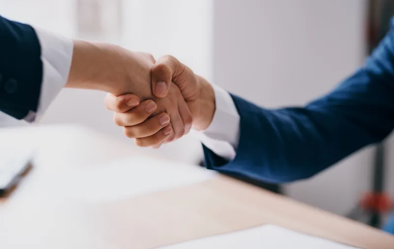Деловые люди пожимают друг другу руки на работе