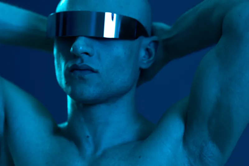 A striking image of a man with sunglasses, showcasing a futuristic vibe and bold emotions. The blue tones create a captivating atmosphere, emphasizing his confident persona.
