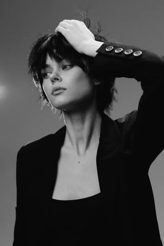 Black and white portrait of a thoughtful woman with short hair wearing a black blazer.