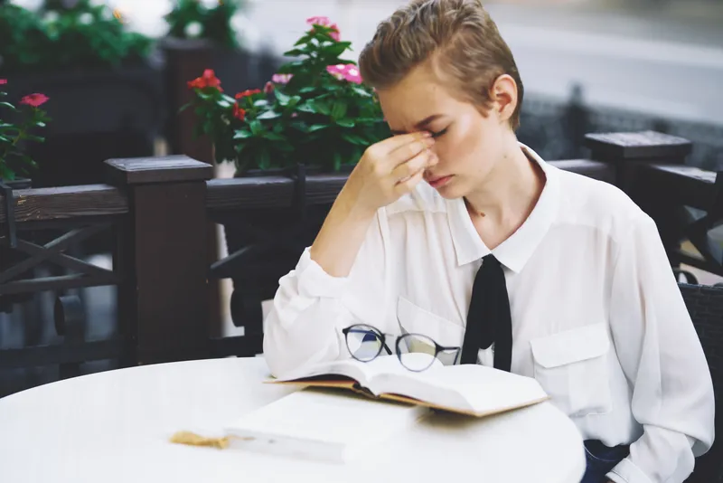 Женщина читает книгу за столиком в ресторане