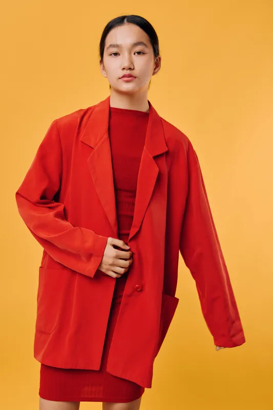Young woman wearing red jacket and dress standing against yellow background, fashion style portrait with modern casual outfit for autumn or winter season, confident pose