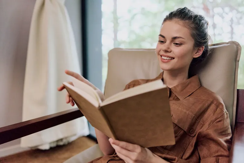 Молодая женщина наслаждается чтением книги в уютном помещении