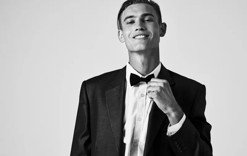 Элегантный джентльмен в классическом костюме с бабочкой на шее, портрет в черно-белой фотографии