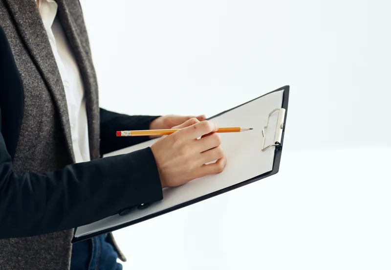 Женщина с папкой документов на светлом фоне, работающая в офисе