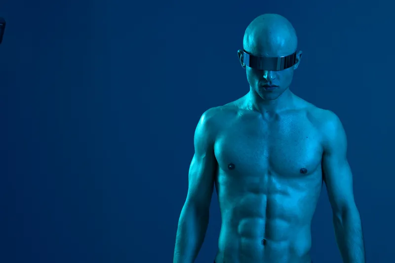 Futuristic man with sunglasses, showcasing a sleek and modern appearance. The blue color palette enhances the image’s unique vibe and style, creating a striking visual impact.