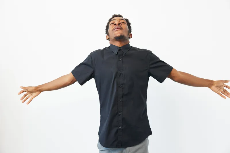 Black man expressing joy with open arms, showcasing happiness and freedom. A powerful representation of positivity and celebration in life.