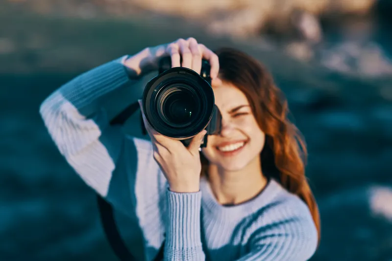 Симпатичная женщина-фотограф на фоне скалистых гор, крупный план, профессиональный снимок