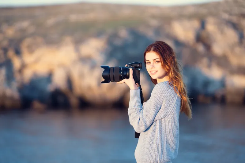 Женщина с фотоаппаратом в руках, профессиональная фотография, скалистые горы, путешествие