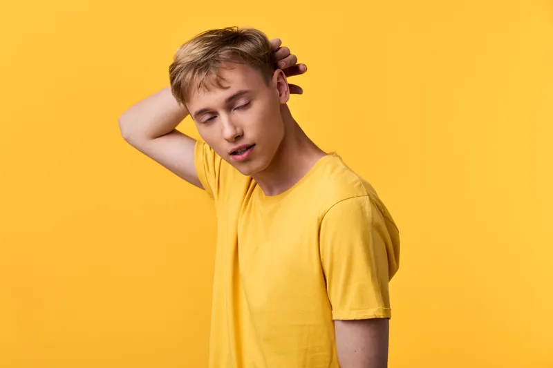 Yellow shirt, young man against a bold yellow backdrop, casual fashion vibe with relaxed stance, clean lighting and minimal styling for lifestyle or catalog use