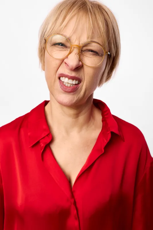 Woman senior portrait, glasses, laughter, blonde hair, red shirt, studio shot on white background, smiling face, cheerful expression, closeup headshot, friendly mood