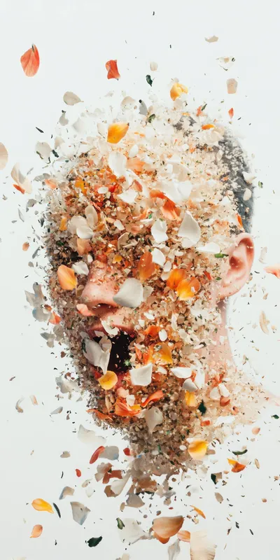 Художественное изображение головы модели, сливающейся с красочными лепестками цветов и природными текстурами, передающее темы красоты, природы и трансформации