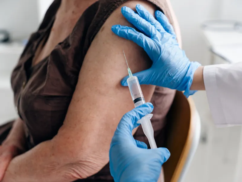 Инъекция шприцем крупным планом в плечо пациента, вакцины, паспорт COVID-19