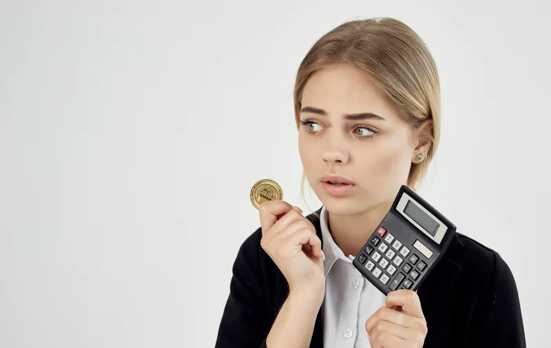 Эмоциональная женщина с калькулятором, криптовалюта Биткоин, финансы
