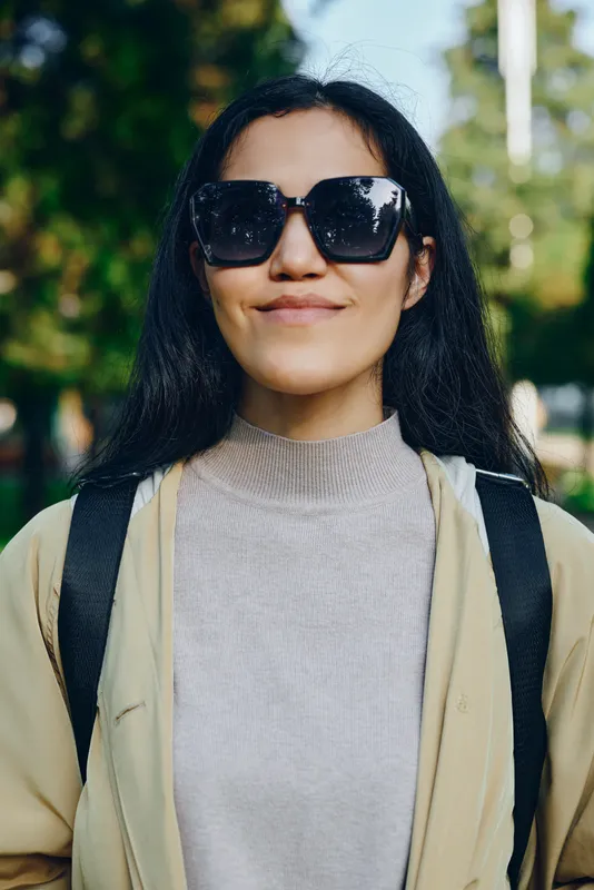 Sunglasses, woman, outdoor, fashion, casual, smile, cardigan, sweater and backpack showcase a relaxed, modern look during daytime streetwear, urban style and confident everyday charm