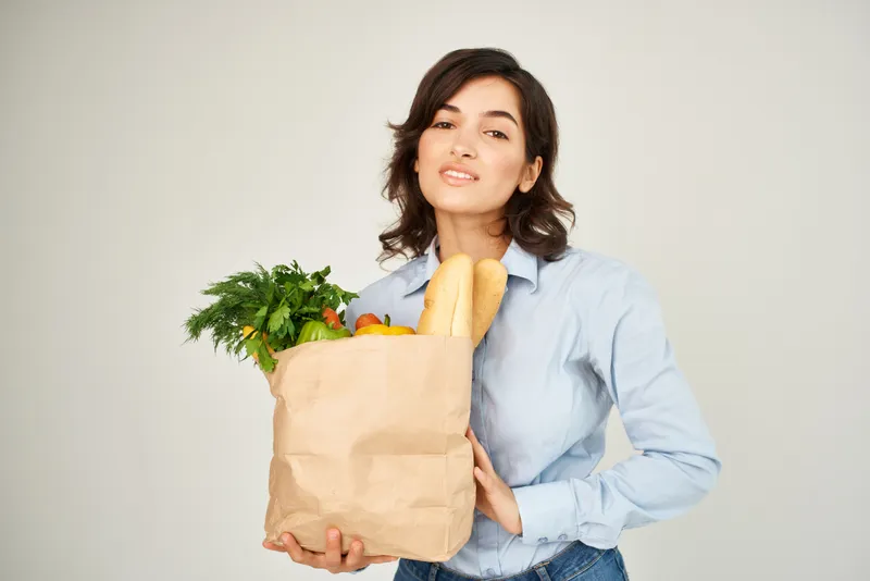 Женщина с пакетом овощей и продуктов из супермаркета, крупный план