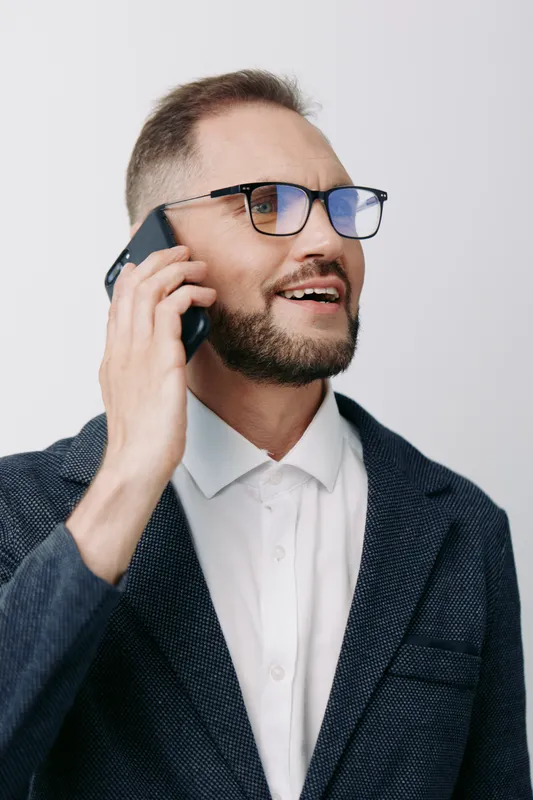 Professional man on the phone, business image with confident and focused emotion, isolated colored background, polished style, executive presence, calm and capable demeanor, ideal for corporate