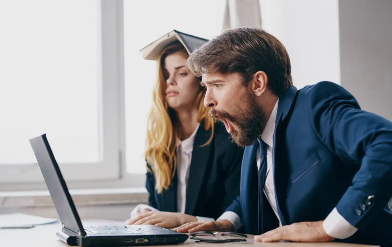 Мужчина и женщина работают за столом с ноутбуком, технологии, офис, эмоции, общение