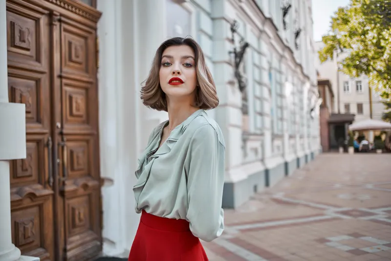 Жизнерадостная женщина на улице, прогуливается возле здания