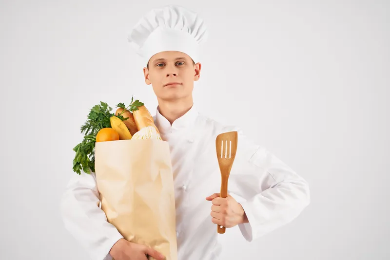 Мужчина в униформе шеф-повара занимается доставкой продуктов из супермаркета
