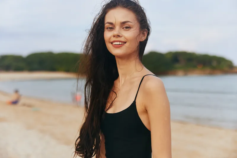 Женщина в платье бежит по пляжу на закате