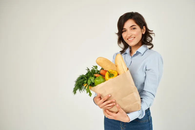 Весёлая женщина с пакетом продуктов, овощей и других продуктов здорового питания, доставка еды