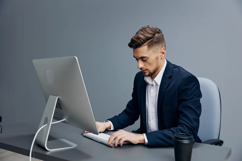 Мужчина в костюме пьет кофе, уставший на работе, на столе документы, руководитель