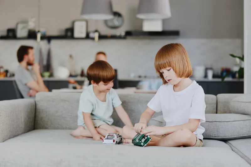Engaging children playing with toy cars in a cozy living room, showcasing creativity, fun, and togetherness in a homey atmosphere.