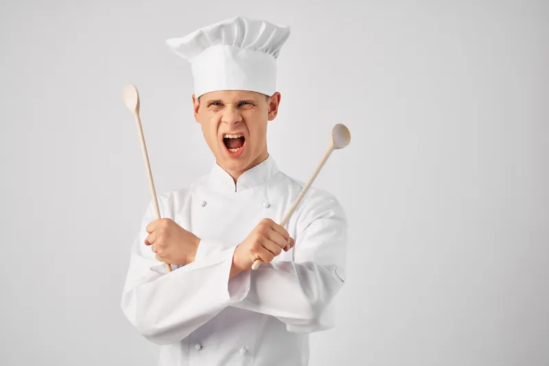 Шеф-повар с кухонной утварью в ресторане, профессиональная работа по приготовлению пищи