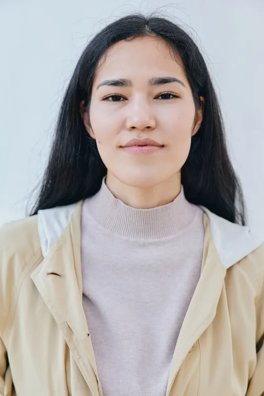 Woman, face, expression, beige jacket and light sweater, neutral tones, close up head and shoulders, minimal styling, suitable for fashion, lifestyle, beauty, and professional profile imagery with