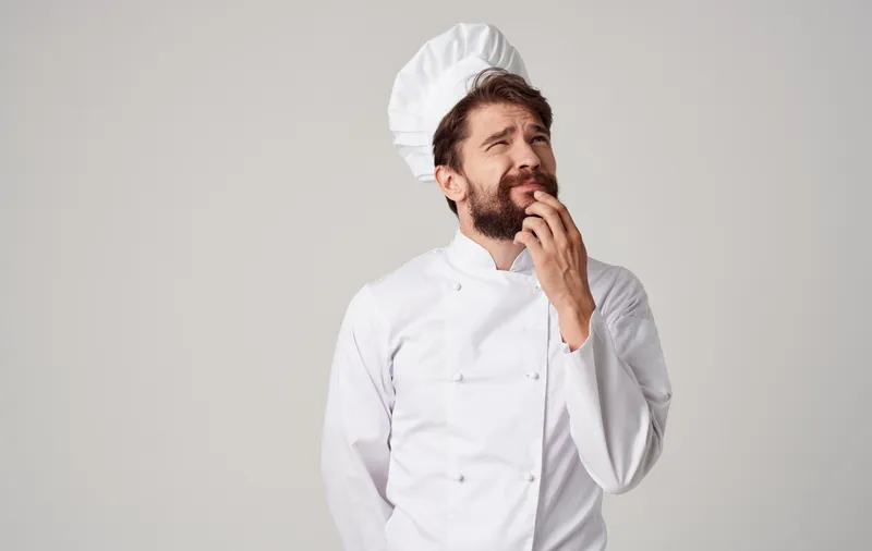 Повар-мужчина, профессионал, работающий на кухне, готовит еду
