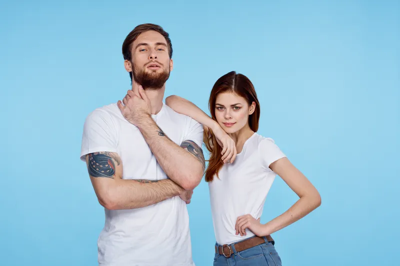 Молодая пара в белых футболках, модный современный стиль, синий фон