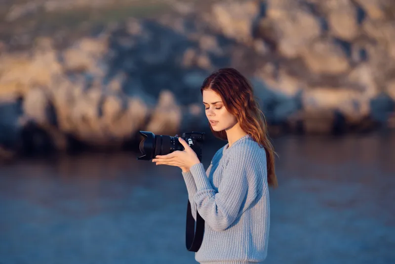 Женщина-туристка с фотоаппаратом на фоне скалистых гор, путешествие, профессионалы