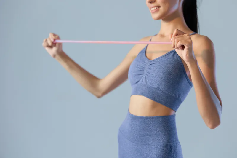 woman sport fitness stretching with resistance band, wearing blue workout clothes, indoors, healthy lifestyle and active exercise concept