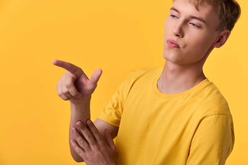 Thinking man expression yellow shirt gesture in a bright studio casual mood minimal background confident pose suitable for lifestyle fashion and creative concept