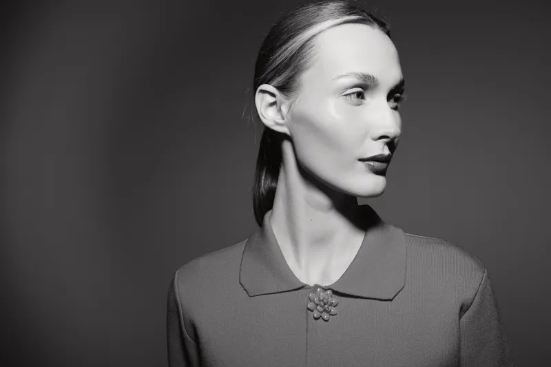Portrait of a young Caucasian woman with fair skin in vintage style clothes looking sideways. Concept of retro fashion, elegance, and classic beauty in black and white.