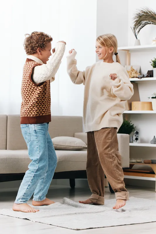 Authenticity in a warm home setting as children engage in a playful game, highlighting a genuine lifestyle moment with a light, educational vibe and friendly energy.