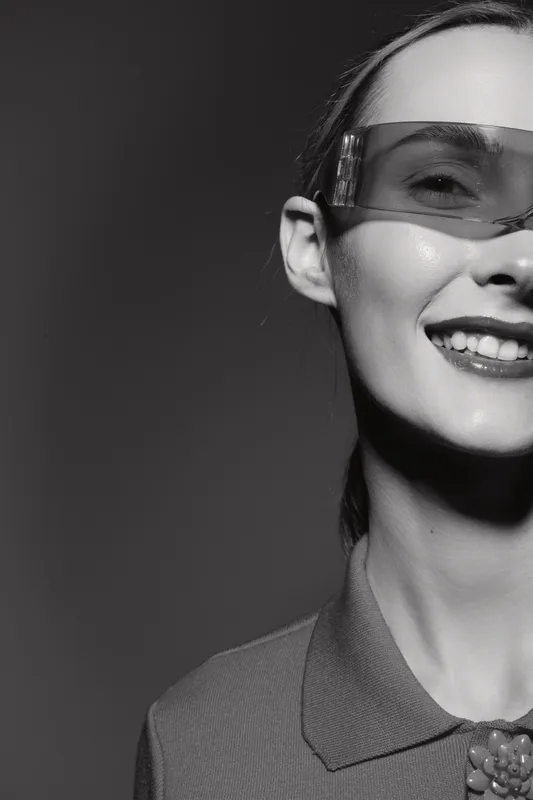 Portrait of a smiling caucasian woman wearing protective glasses in monochrome. Concept of safety, healthcare, and positive emotions in industry or lab.