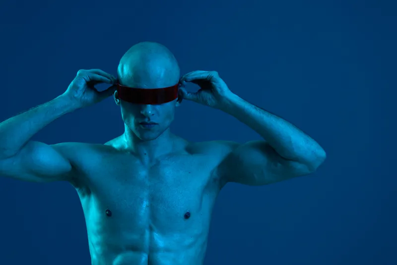 Futuristic man with a sleek visor, showcasing a bold, blue aesthetic. The image captures an ethereal ambiance while highlighting a modern style.