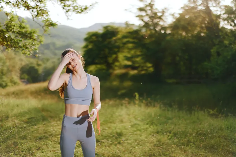 Young fit woman in sportswear enjoying nature while exercising, representing a healthy lifestyle concept in outdoor setting with vibrant colors and positive emotions