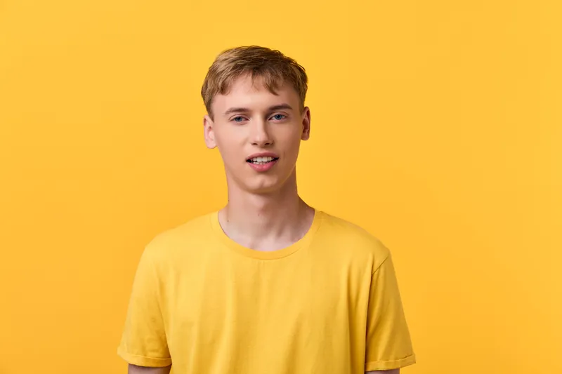 Casual man in a yellow t shirt against a bright yellow background, a simple studio shot with a relaxed mood, showcasing everyday fashion, clean composition and vibrant color palette