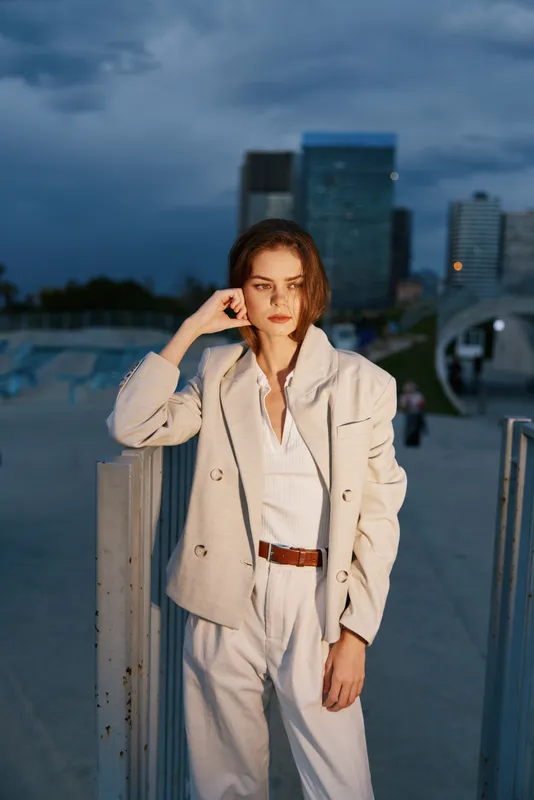 woman in beige business suit with serious expression urban evening background financial crisis concept