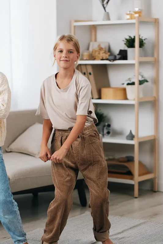 Authenticity shines in a playful home scene as a child moves with joy, blending lifestyle moments with school inspired energy and spontaneous play.