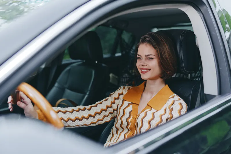 Car, driver, woman, smile a cheerful woman sits confidently in the driver's seat, hand on the steering wheel, radiating joy, readiness for a smooth journey and new adventures ahead.
