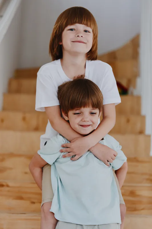 Two joyful boys playing together indoors, showcasing their playful spirits and brotherly bond in a charming home environment with natural light.