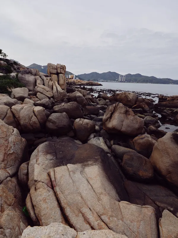 Rocky coastal landscape with rugged stones and distant mountains, capturing the serene beauty of nature in a tranquil setting Perfect for travel and outdoor themes