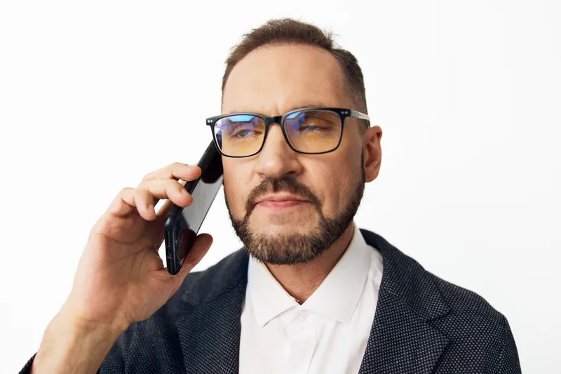 A professional business man on a call, displaying confidence and focus as he speaks on the phone, set against an isolated colorful background.